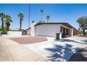 Exterior view of home with large concrete driveway, desert landscaping, and an attached fence at 3646 W Brown St, Phoenix, AZ 85051