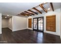 Spacious living room features dark wood floors, exposed ceiling beams, and stylish window coverings at 3646 W Brown St, Phoenix, AZ 85051