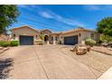 Charming single-story home with a desert landscape, a spacious driveway and a three-car garage at 3824 E Parkside Ln, Phoenix, AZ 85050