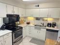 Well-lit kitchen with stainless steel appliances, white cabinets, and ample counter space at 4201 E Camelback Rd # 51, Phoenix, AZ 85018