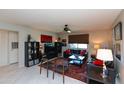 Well-lit living room features neutral walls, tile flooring, black sofas, ceiling fan, and storage at 4201 E Camelback Rd # 51, Phoenix, AZ 85018