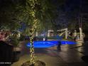 Sparkling pool surrounded by trees adorned with festive lights in a serene backyard setting at 6139 E Voltaire Ave, Scottsdale, AZ 85254
