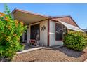 Welcoming front of home with a covered porch, rocking chair, and vibrant flowering bushes at 8103 E Southern Ave # 75, Mesa, AZ 85209