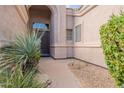 Home entryway featuring desert landscaping and a dark front door with sidelight window at 9678 E Voltaire Dr, Scottsdale, AZ 85260