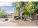 Exterior view showcasing the desert landscaping, curved walkway, and lush trees at 9678 E Voltaire Dr, Scottsdale, AZ 85260