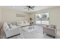 Bright living room featuring neutral tones, a ceiling fan, and sliding glass doors to the backyard at 11215 N 38Th N Ave, Phoenix, AZ 85029