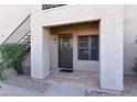 Unit entrance featuring tile entry, security door, and trimmed bushes in gravel yard at 14910 N Kings Way # 105, Fountain Hills, AZ 85268