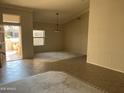 Inviting living space with tile flooring, neutral walls, and abundant natural light from the front door at 15314 W Camino Estrella Dr, Surprise, AZ 85374
