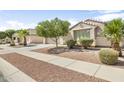 Inviting single-story home showcases desert landscaping, a spacious driveway, and a two-car garage at 17820 W Charter Oak Rd, Surprise, AZ 85388