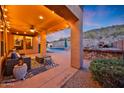 Covered patio with a cozy seating area, outdoor kitchen, pizza oven, and a view of the refreshing pool at 18121 W Las Cruces Dr, Goodyear, AZ 85338