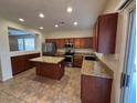Charming kitchen with granite countertops, stainless appliances, and an island with breakfast bar at 20985 N 81St Dr, Peoria, AZ 85382