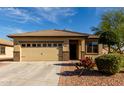 Inviting home with a well-kept front yard showcasing desert landscaping and a brick-accented facade at 22417 W Loma Linda Blvd, Buckeye, AZ 85326