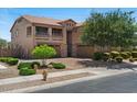 Home exterior featuring a three-car garage, balconies, desert landscaping, and a brick driveway at 23081 S 223Rd Way, Queen Creek, AZ 85142
