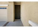 Close-up of the front door with textured exterior walls, and a view of the attached garage at 23733 S 209Th Pl, Queen Creek, AZ 85142
