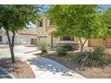 Charming home with mature landscaping, including desert plants and trees, on a sunny day with a walkway at 23733 S 209Th Pl, Queen Creek, AZ 85142