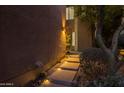 Illuminated walkway leads to the entrance of this desert home, lined with desert landscaping at 25555 N Windy Walk Dr # 34, Scottsdale, AZ 85255