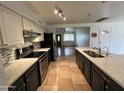 Open-concept kitchen with granite counters, stainless steel appliances, and eat-in island at 2838 E Contessa St, Mesa, AZ 85213