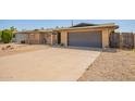 Picture of a single story house with a large driveway, desert landscaping, and an attached garage at 3825 W Royal Palm Rd, Phoenix, AZ 85051