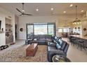 Living room with large windows and ceiling fan, open to kitchen and dining areas at 4008 La Ultima Piedra --, Carefree, AZ 85377