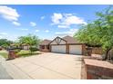 Beautiful home with brick accents, a lush lawn, and a large driveway leading to a two-car garage at 4353 W Villa Rita Dr, Glendale, AZ 85308