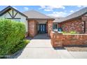 Inviting brick home entrance featuring a vibrant blue double-door and neatly manicured shrubs at 4353 W Villa Rita Dr, Glendale, AZ 85308