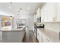 Well-lit kitchen with white cabinets, marble countertops, stainless steel appliances and an open design at 4360 N 186Th Ln, Goodyear, AZ 85395