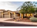 Inviting single-story home with desert landscaping, illuminated entryway steps and a three-car garage at 4422 E Spur Dr, Cave Creek, AZ 85331