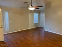 Spacious living room featuring hardwood floors, a ceiling fan, and plenty of natural light at 4533 E Glenhaven Dr, Phoenix, AZ 85048