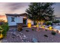 Inviting single story home with drought tolerant landscaping, stone accents and ambient outdoor lighting at dusk at 5212 S Seton Ct, Gilbert, AZ 85298