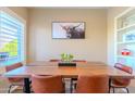 Dining room with wood table, leather chairs, stylish decor, and natural light from a large window at 5345 E Van Buren St # 307, Phoenix, AZ 85008