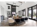 Open living and dining area with a fireplace, high ceilings, modern decor, and abundant natural light at 5929 E Indian School Rd, Phoenix, AZ 85018