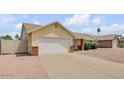 Single-story home featuring a two-car garage, brick accents, and well-maintained landscaping at 6102 E Inglewood St, Mesa, AZ 85205