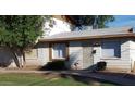 Charming single-story home with white siding, mature trees, and well-maintained landscaping at 7109 W Wolf St, Phoenix, AZ 85033