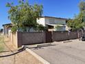 Gated parking area with mature tree at 7109 W Wolf St, Phoenix, AZ 85033
