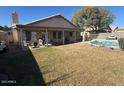 Expansive backyard featuring a pool, lush lawn, and covered patio for outdoor enjoyment at 7813 E Covina St, Mesa, AZ 85207