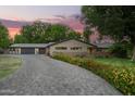 Beautiful home with a winding brick driveway, flowering plants, and mature landscaping on a spacious lot at 8302 S Jentilly Ln, Tempe, AZ 85284