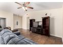 Comfortable living room with a large television, ceiling fan, and tile flooring at 937 N Marble St, Gilbert, AZ 85234