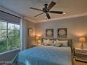 Well-lit bedroom featuring a queen-sized bed, soft lighting, and a large window with lush, green views at 9450 E Becker Ln # 2099, Scottsdale, AZ 85260