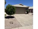 Exterior view showing a two-car garage, driveway, and desert landscaping in front at 1040 W Juniper Ave, Gilbert, AZ 85233