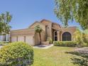 Stunning home featuring a lush lawn, mature landscaping, and a convenient three-car garage, combining elegance and functionality at 13064 N 100Th Pl, Scottsdale, AZ 85260