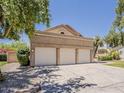 A home with a three-car garage, mature trees, and meticulously maintained landscaping for a welcoming curb appeal at 13064 N 100Th Pl, Scottsdale, AZ 85260