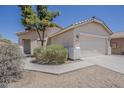 Single-story home with desert landscaping, beige stucco, and a two-car garage at 15364 W Acapulco Ln, Surprise, AZ 85379