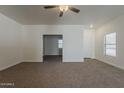 Living room with neutral walls, ceiling fan and carpet, and white trim at 15364 W Acapulco Ln, Surprise, AZ 85379