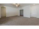 Bright living room featuring neutral walls, plush carpeting, and a ceiling fan at 15364 W Acapulco Ln, Surprise, AZ 85379