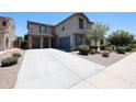 Home featuring a long driveway leading to a two-car garage, with desert landscaping at 16475 N 183Rd Dr, Surprise, AZ 85388