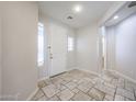 Bright foyer with travertine tile flooring, natural light, and a view into the house at 16475 N 183Rd Dr, Surprise, AZ 85388