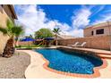 Stunning backyard pool with lounge chairs, umbrellas, and lush green lawn, perfect for relaxation and entertainment at 16565 W Garfield St, Goodyear, AZ 85338