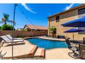 Inviting backyard pool with lounge chairs, manicured landscaping, and clear blue water on a sunny day at 16565 W Garfield St, Goodyear, AZ 85338