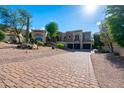Beautiful home features a three-car garage, decorative stone accents, and desert landscaping on a sunny day at 18425 W Santa Irene Dr, Goodyear, AZ 85338