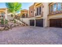 Stunning home featuring a three-car garage, decorative stone accents, and professionally landscaped desert-style yard at 18425 W Santa Irene Dr, Goodyear, AZ 85338